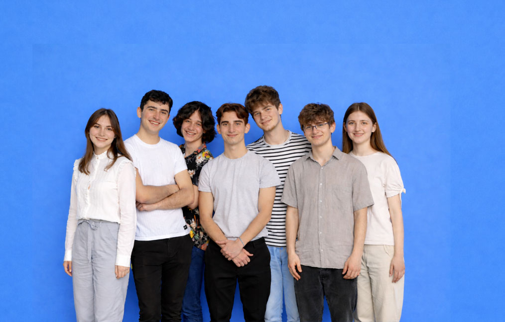 Seven young students looking at the camera with smiling faces
