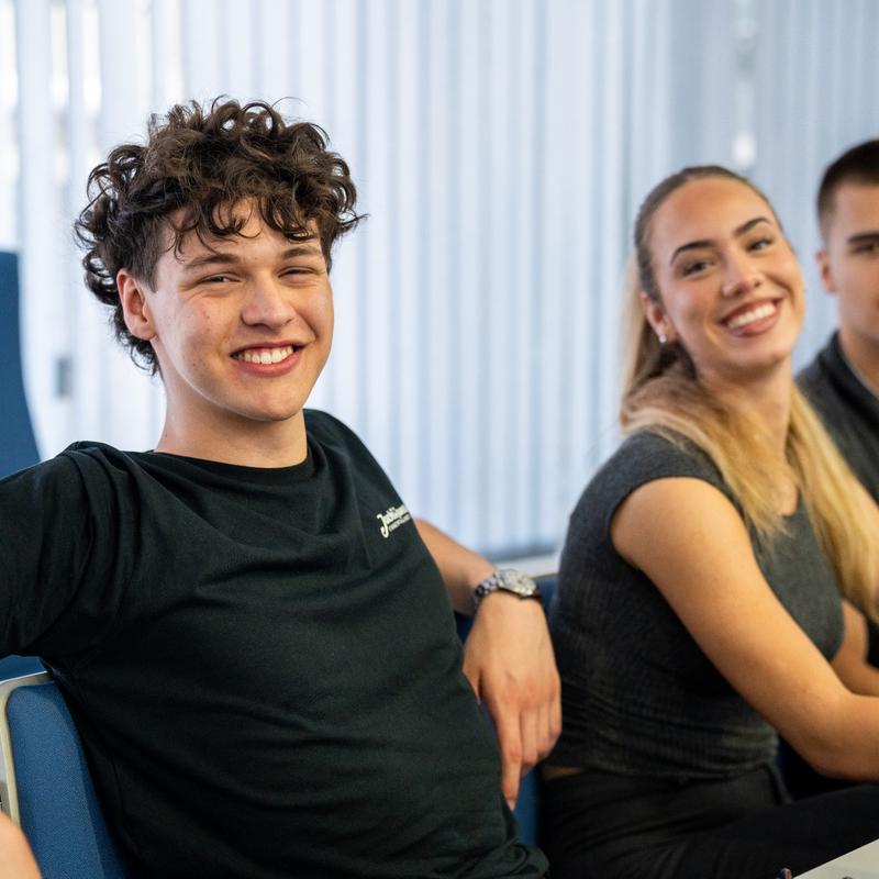 A male and female student sat down, smiling broadly at the camera