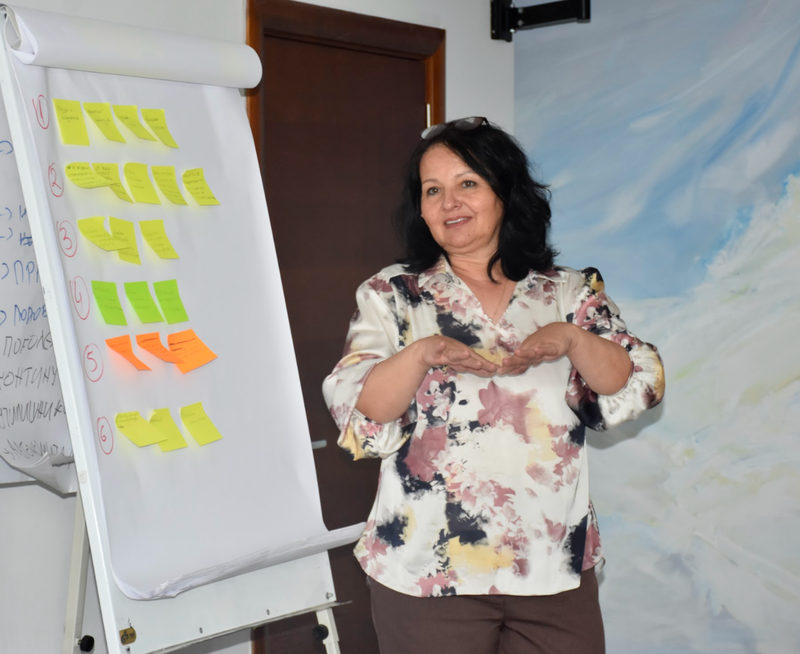 A female teacher trainer smiling and engaging in a workshop