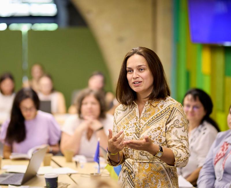 A teacher training participant stood up, talking to the lead