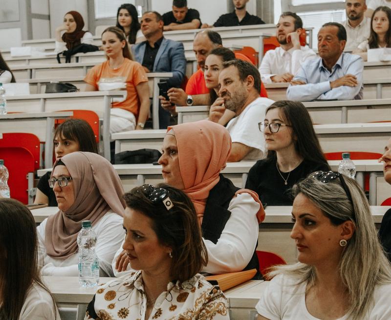 Close up in a lecture hall of adults looking to the front of the room